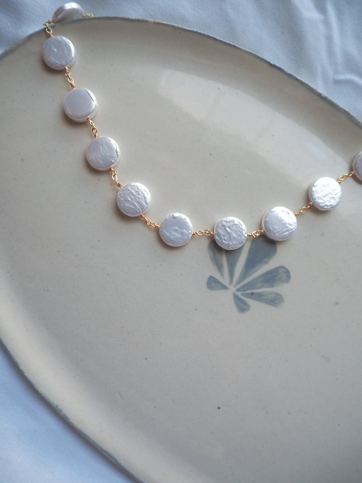 Pearl necklace with gold chain flat lay product photo