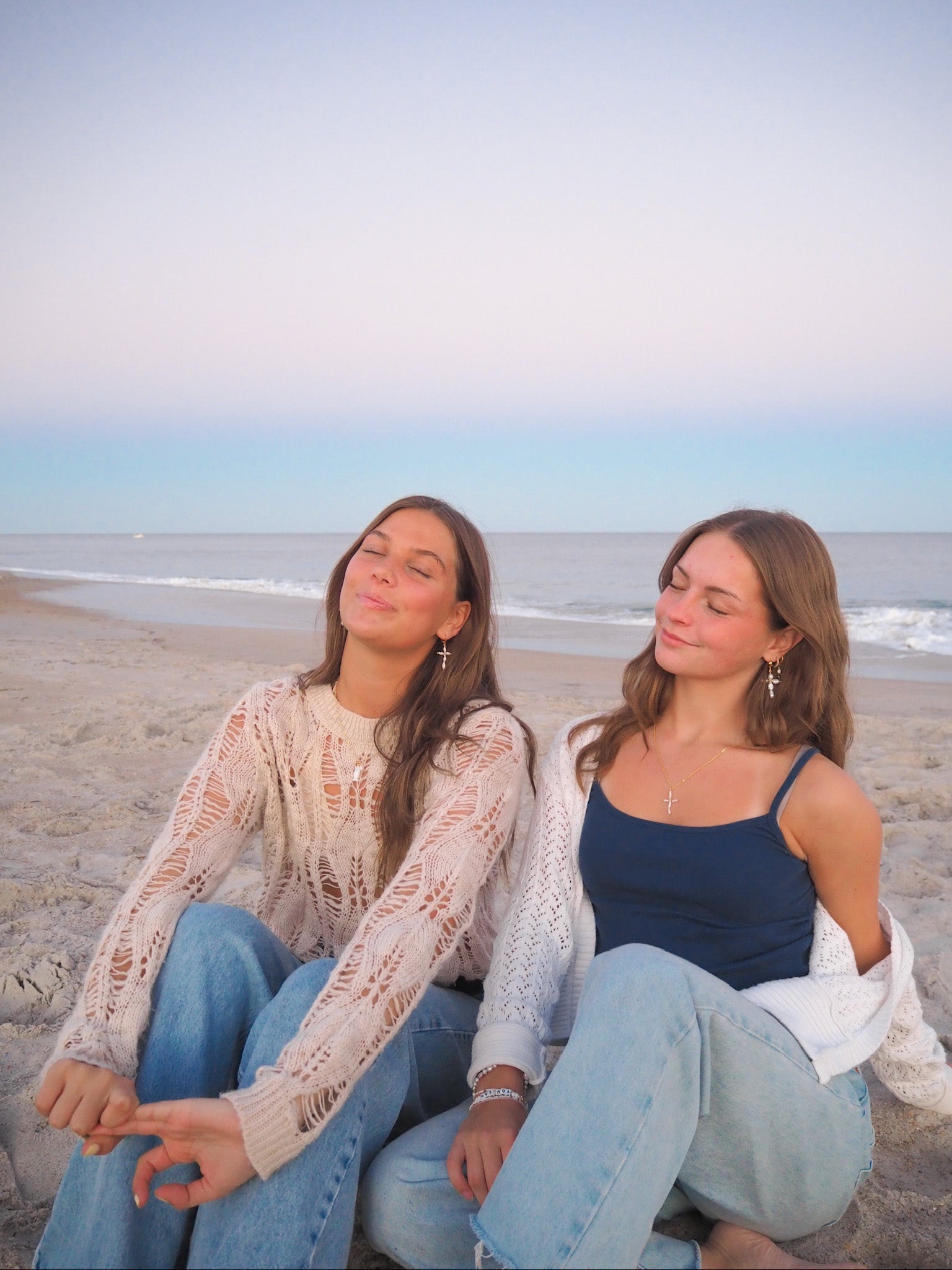 Dainty Pearl Cross Earrings handmade jewelry styled on beach at sunset