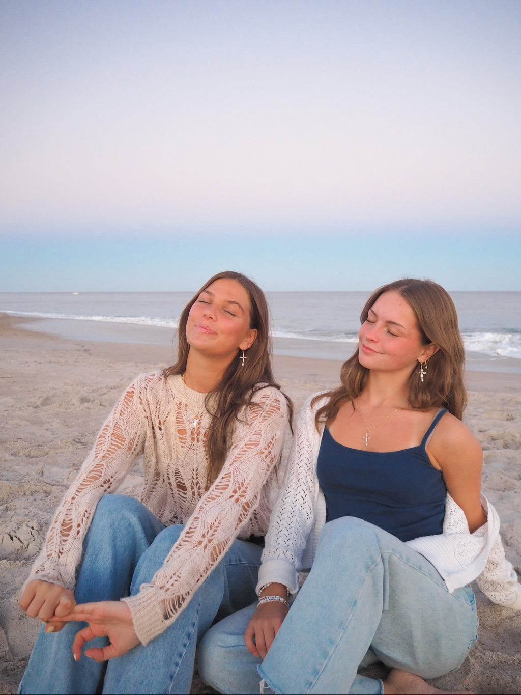 Dainty Pearl Cross Earrings handmade jewelry styled on beach at sunset