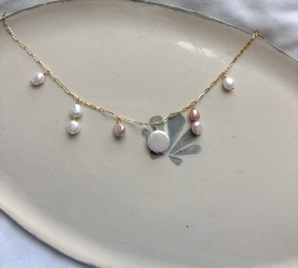 Isla Pearl Necklace beach jewelry featuring freshwater pearls on gold chain flat lay