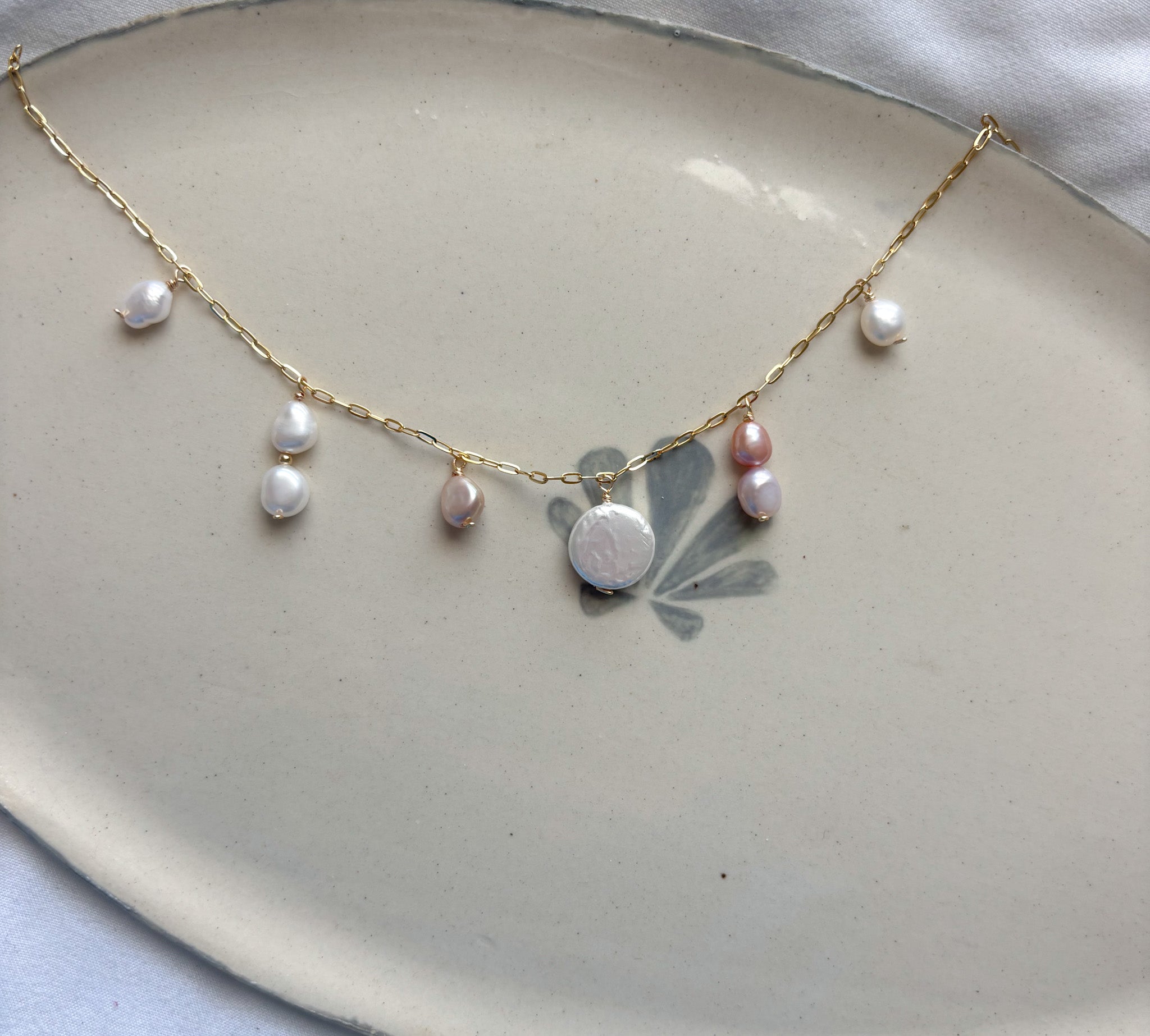 Isla Pearl Necklace beach jewelry featuring freshwater pearls on gold chain flat lay